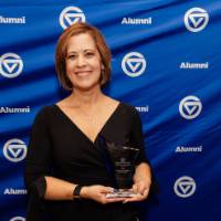 Joyce Ohm smiles holding her award